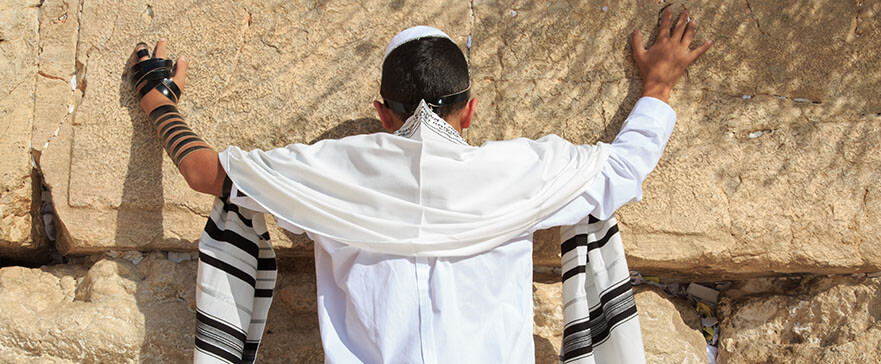 Jewish teenager praying at the Western wall in Jerusalem