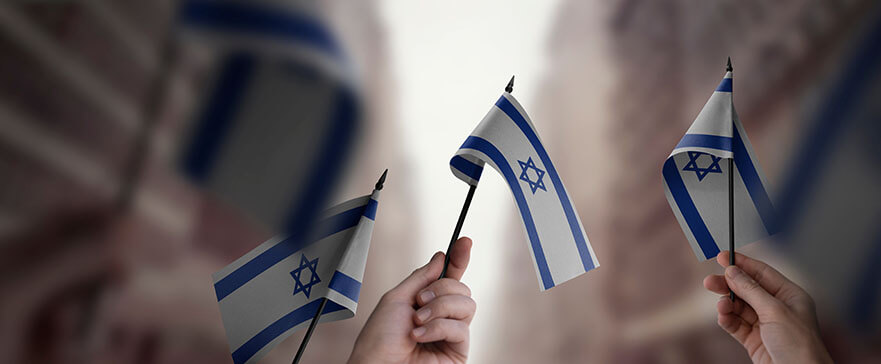 A group of people holding small flags of the Israel in their hands